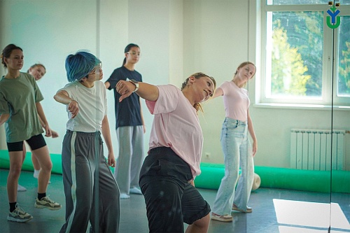 Пять студентов с руководителем студии выполняют танцевальные движения в просторном зале спортивного комплекса ЮГУ