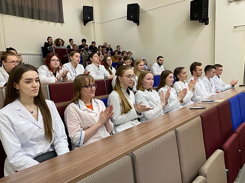 Студент Ханты-Мансийский медакадемии сидят в большой аудитории и аплодируют после лекции, которую провёл эксперт ЮГУ