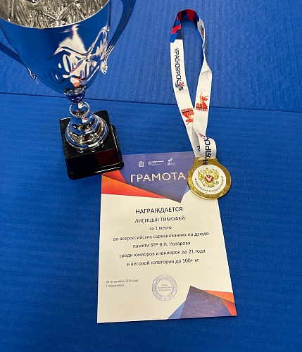 На синем фоне лежит кубок, медаль и грамота с текстом 