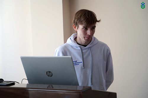 За трибуной стоит председатель литературного клуба ЮГУ КОТ Дмитрий Подрезов рассказывает о достижениях клуба на презентации проекта «КотоТворчество – голос студентов ЮГУ», поддержанного грантом главы города Ханты-Мансийска