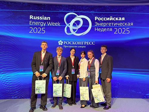 На изображении группа из шести молодых людей стоит перед синим экраном. На экране отображается логотип 