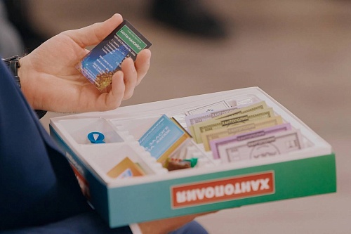 На фотографии изображен мужчина, держащий в руке карточку собственности 