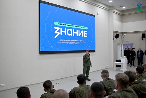 На экране отображается заголовок «Разговор о важном «Герои России»». Под ним крупными белыми буквами написано слово «Знание». Ниже указано «Аксёнов Дмитрий Александрович. Кавалер Ордена Мужества, руководитель Ассоциации ветеранов СВО в Югре, депутат Думы 